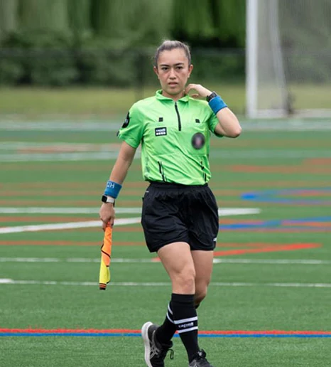 An assistant referee signalling with the flag